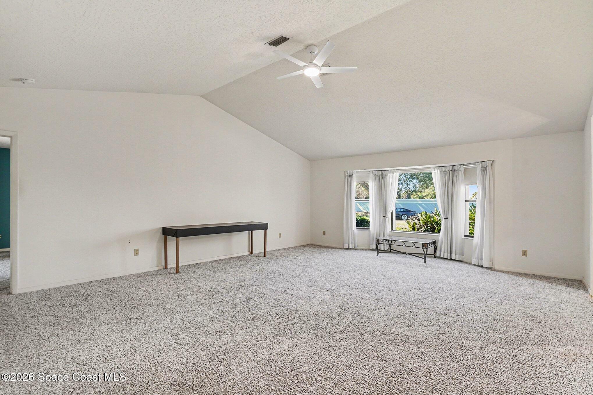 1741 Freedom Drive Melbourne, FL 32940 - Photo 5 of 37 a view of an empty room with a window and a kitchen