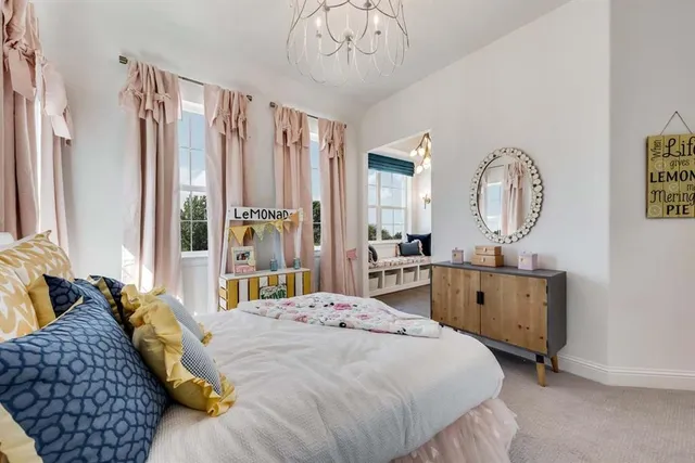 a bedroom with a large bed and a chandelier