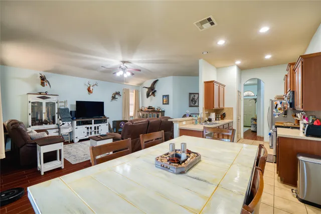 a living room with furniture kitchen view and a flat screen tv