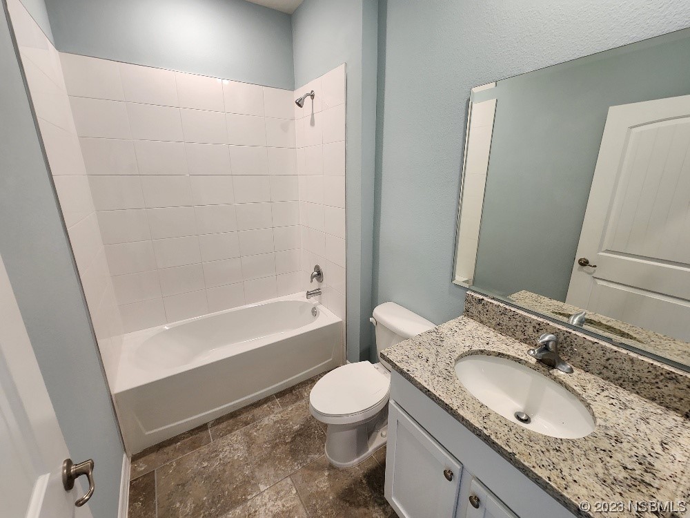 1839 Red Rock Road New Smyrna Beach, FL 32168 - Photo 14 of 23 a bathroom with a granite countertop toilet a sink and a bathtub