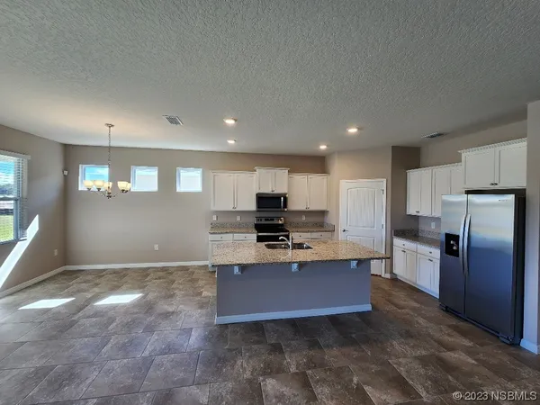 a kitchen with stainless steel appliances granite countertop a refrigerator and a stove