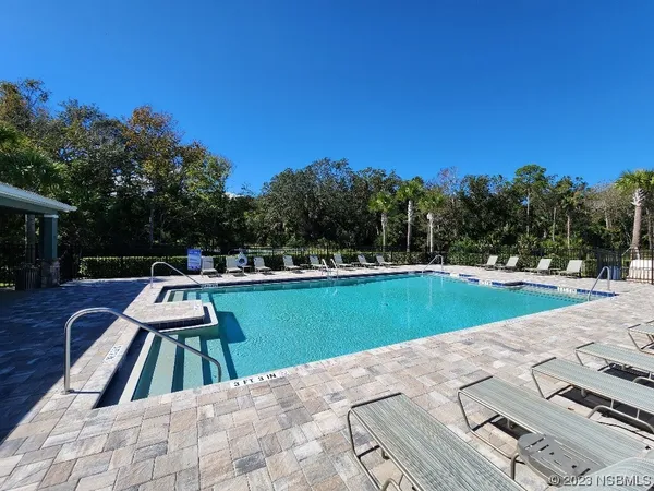 a view of a house with swimming pool and sitting area