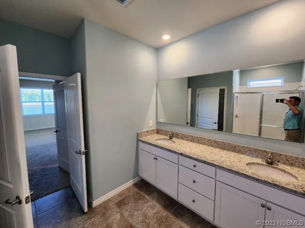 a bathroom with a glass door shower a sink and a mirror