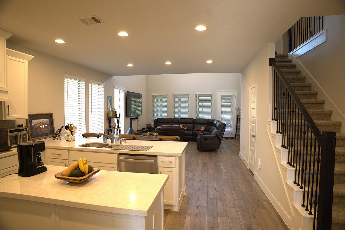 284 Kimble Creek Loop Kyle, TX 78640 - Photo 32 of 32 a kitchen with counter top space a sink wooden floor and stainless steel appliances