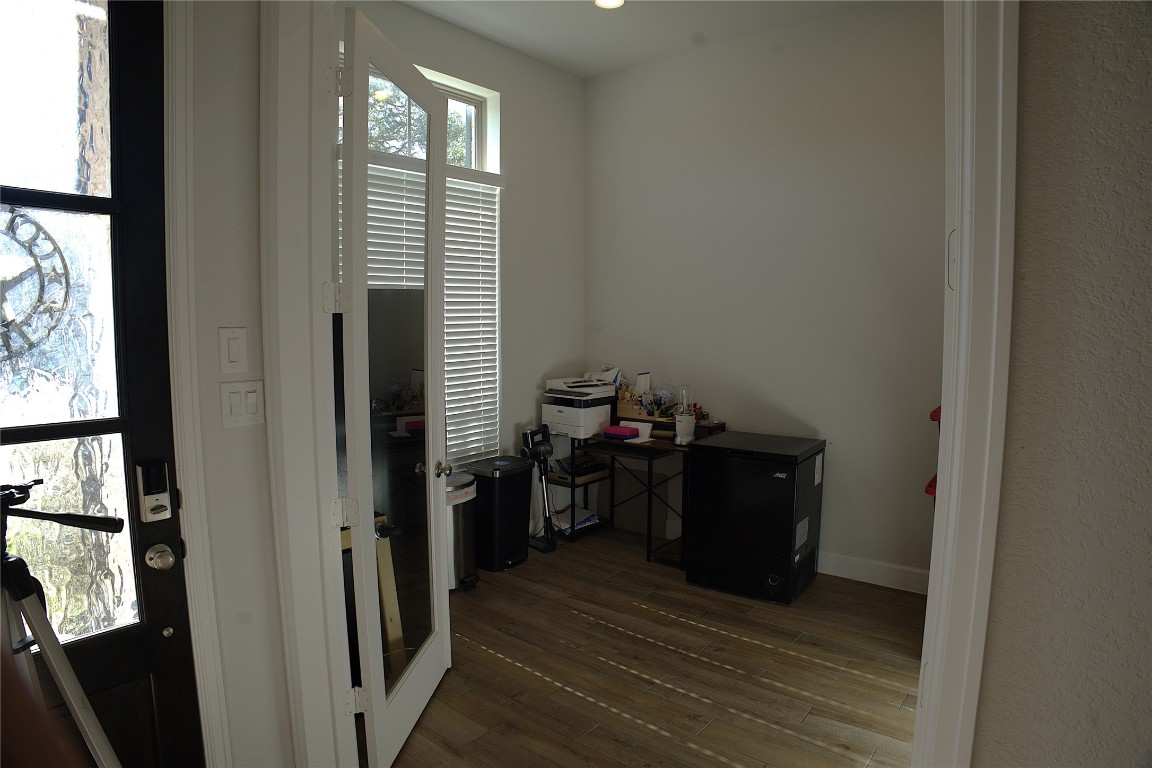 284 Kimble Creek Loop Kyle, TX 78640 - Photo 24 of 32 a room with wooden floor and furniture