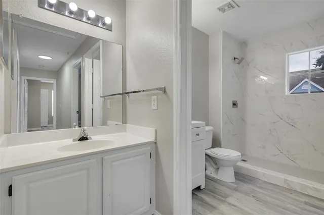 a bathroom with a sink a toilet and shower