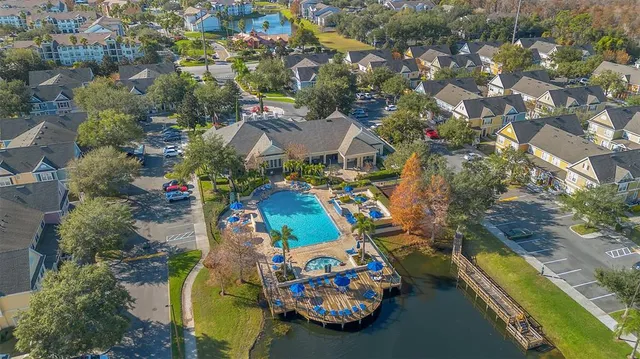 an aerial view of a swimming pool with outdoor seating and yard