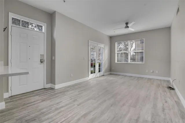 an empty room with wooden floor and windows