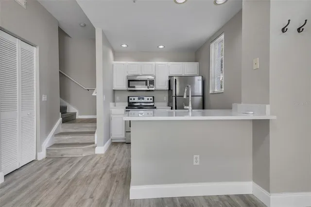 a view of kitchen with wooden floor and electronic appliances