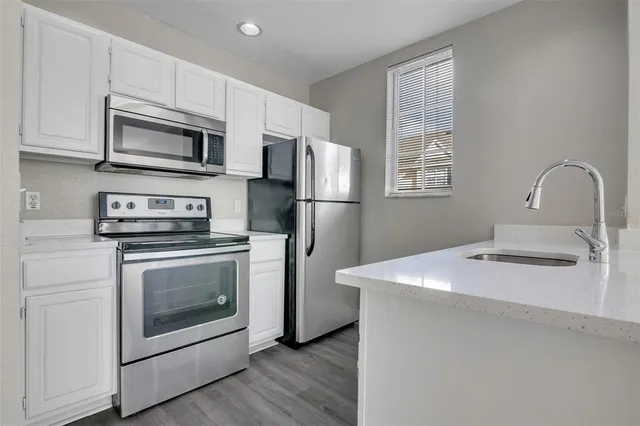 a kitchen with stainless steel appliances a stove microwave and sink