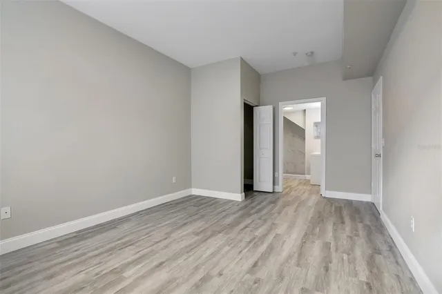 a view of an empty room with closet and a window