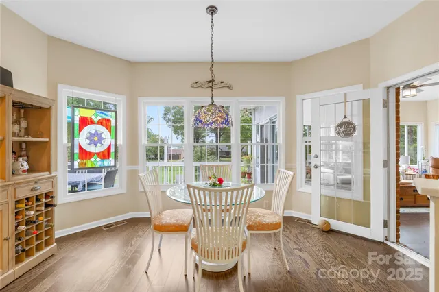 a dining room with furniture a chandelier and wooden floor