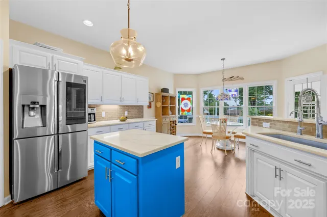 a kitchen with a refrigerator a stove cabinets and wooden floor