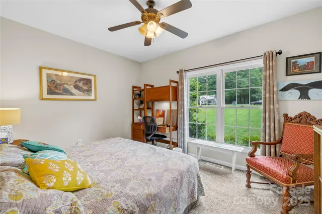 a bedroom with a bed and a large window