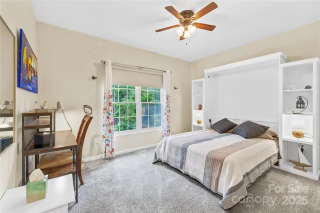 a bedroom with a bed a large window and book shelf