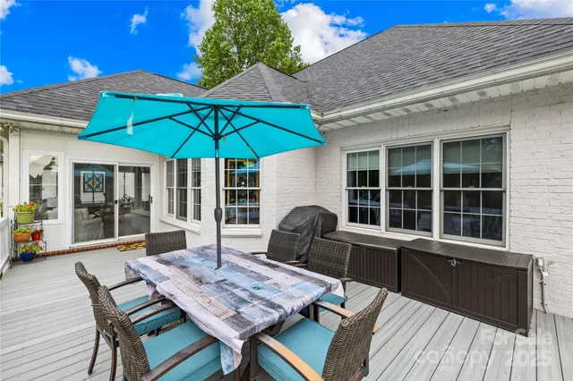 a view of a house with wooden deck and furniture