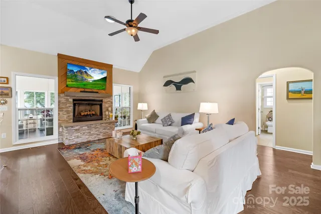 a living room with furniture a fireplace and a flat screen tv