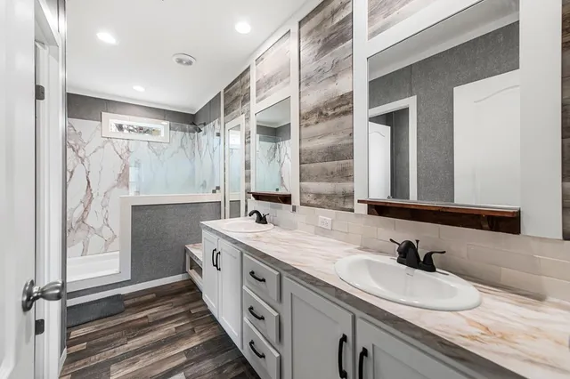 a bathroom with double vanity and a mirror