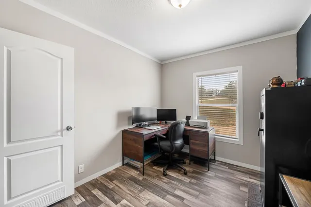 a view of a workspace with furniture and a window