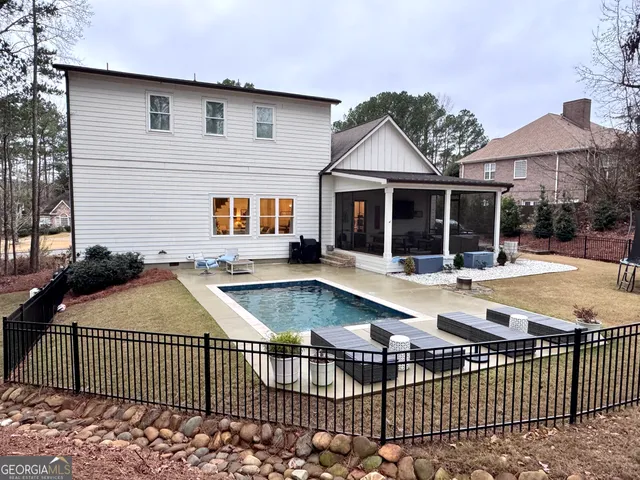 a view of a house with a swimming pool and sitting area