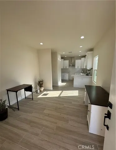 a kitchen with stainless steel appliances kitchen island granite countertop a table chairs in it and wooden floors