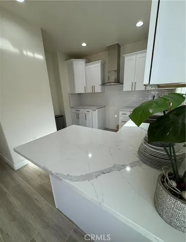 a kitchen with a sink and a stove top oven with wooden floor