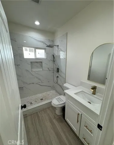 a bathroom with a sink a toilet and shower