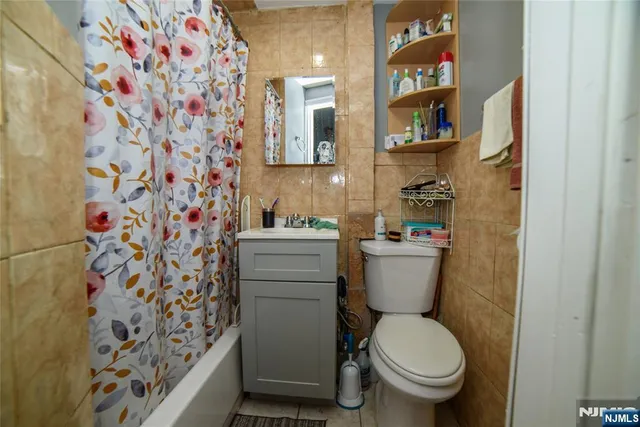 a bathroom with a toilet and a shower curtain
