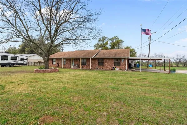 a front view of a house with a garden and trees
