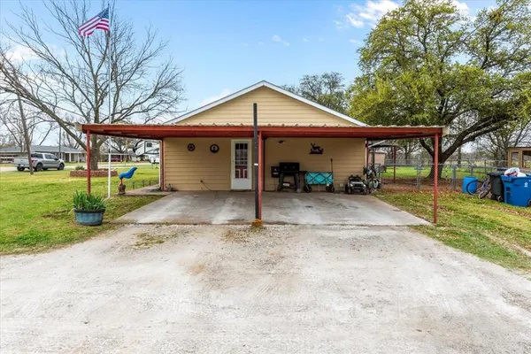 a view of a house with a yard and large tree