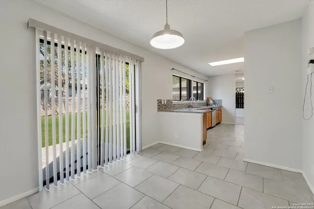 a dining room with furniture potted plants and wooden floor