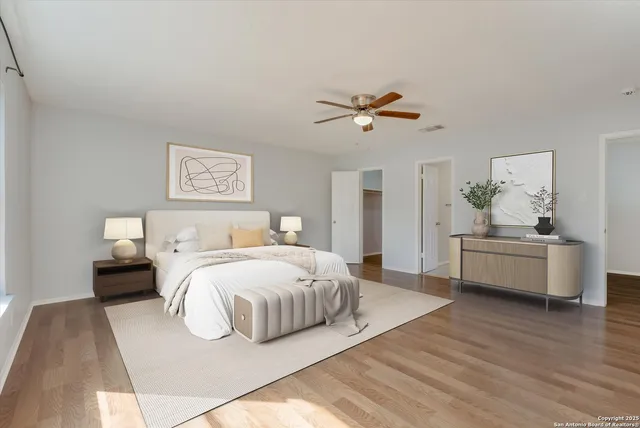 a view of empty room with wooden floor and fan