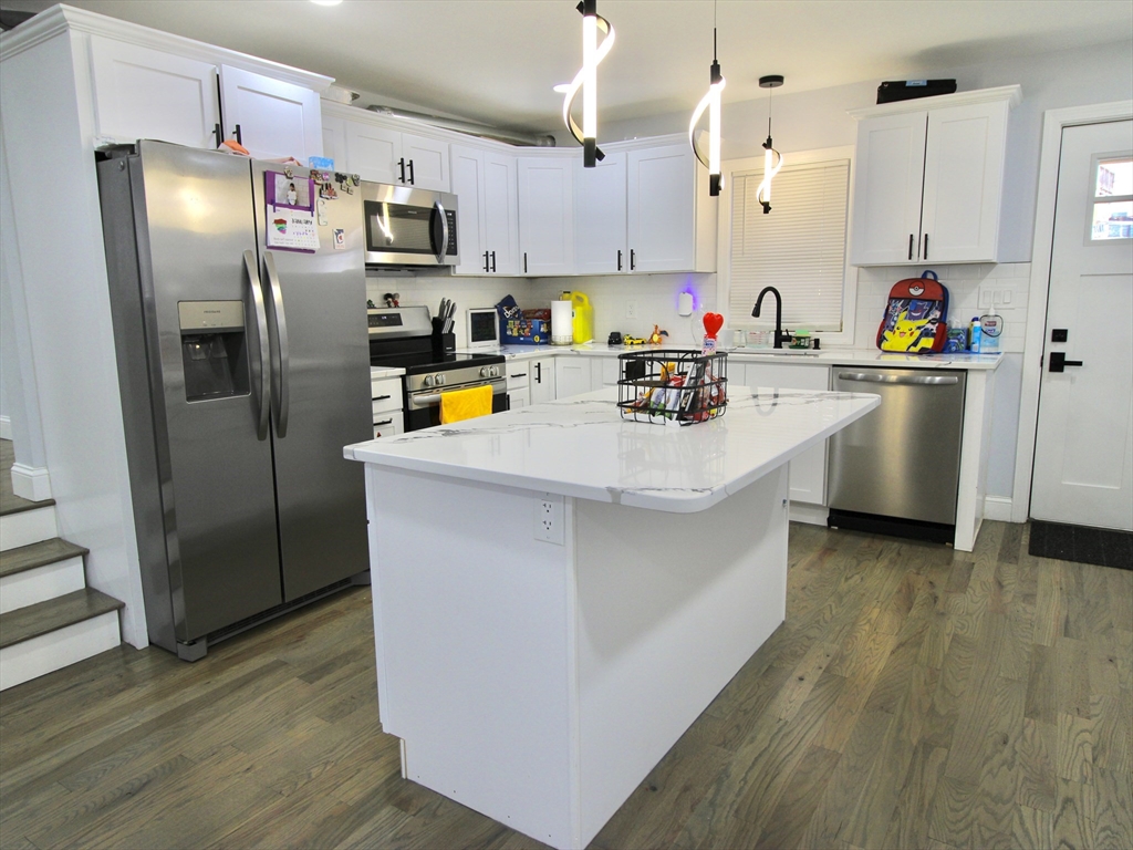 210 Nichols Street Gardner, MA 01440 - Photo 16 of 25 a kitchen with stainless steel appliances a refrigerator sink and wooden floor