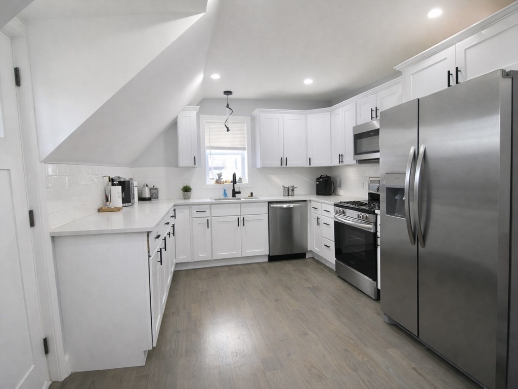 210 Nichols Street Gardner, MA 01440 - Photo 25 of 25 a kitchen with white cabinets stainless steel appliances and a window