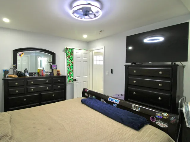 a room with a bed and a mirror on dresser