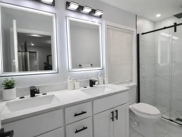 a bathroom with a sink toilet vanity and shower