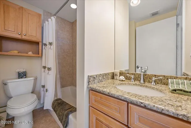 a bathroom with a granite countertop toilet sink and mirror