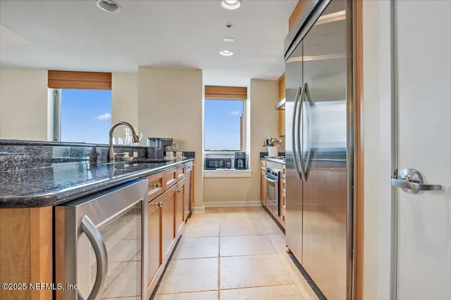 a kitchen with stainless steel appliances granite countertop a refrigerator and a sink