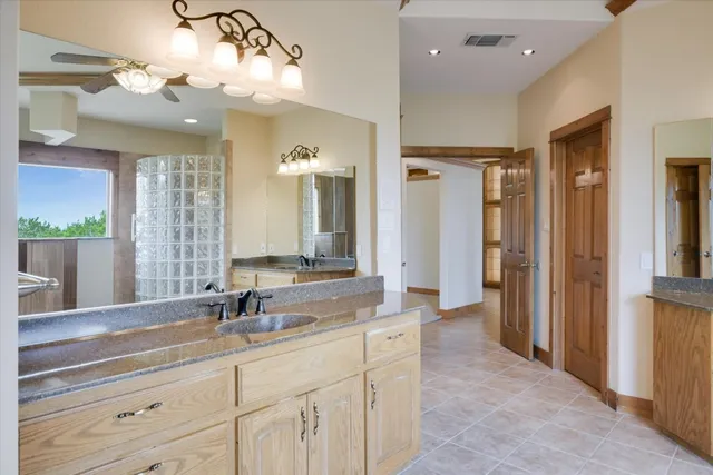 an empty room with windows closet and chandelier fan
