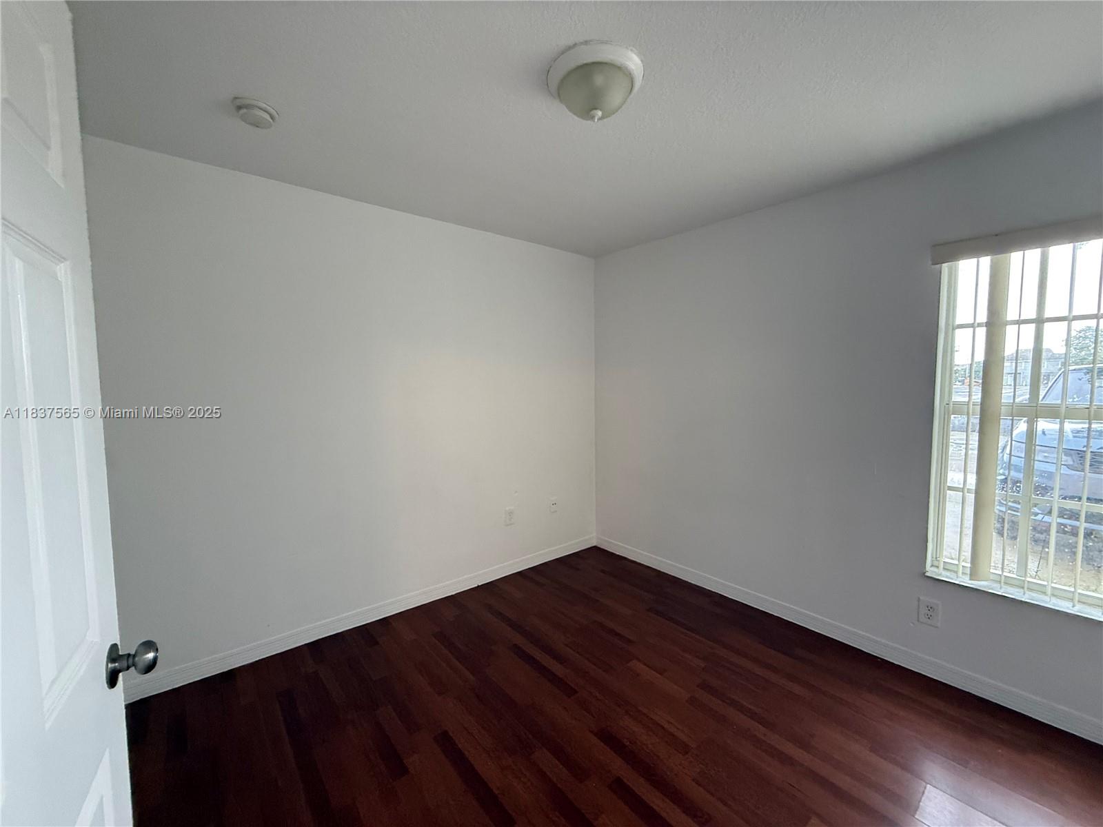 Naranja Homestead, FL 33032 - Photo 12 of 17 a view of an empty room with wooden floor and a window