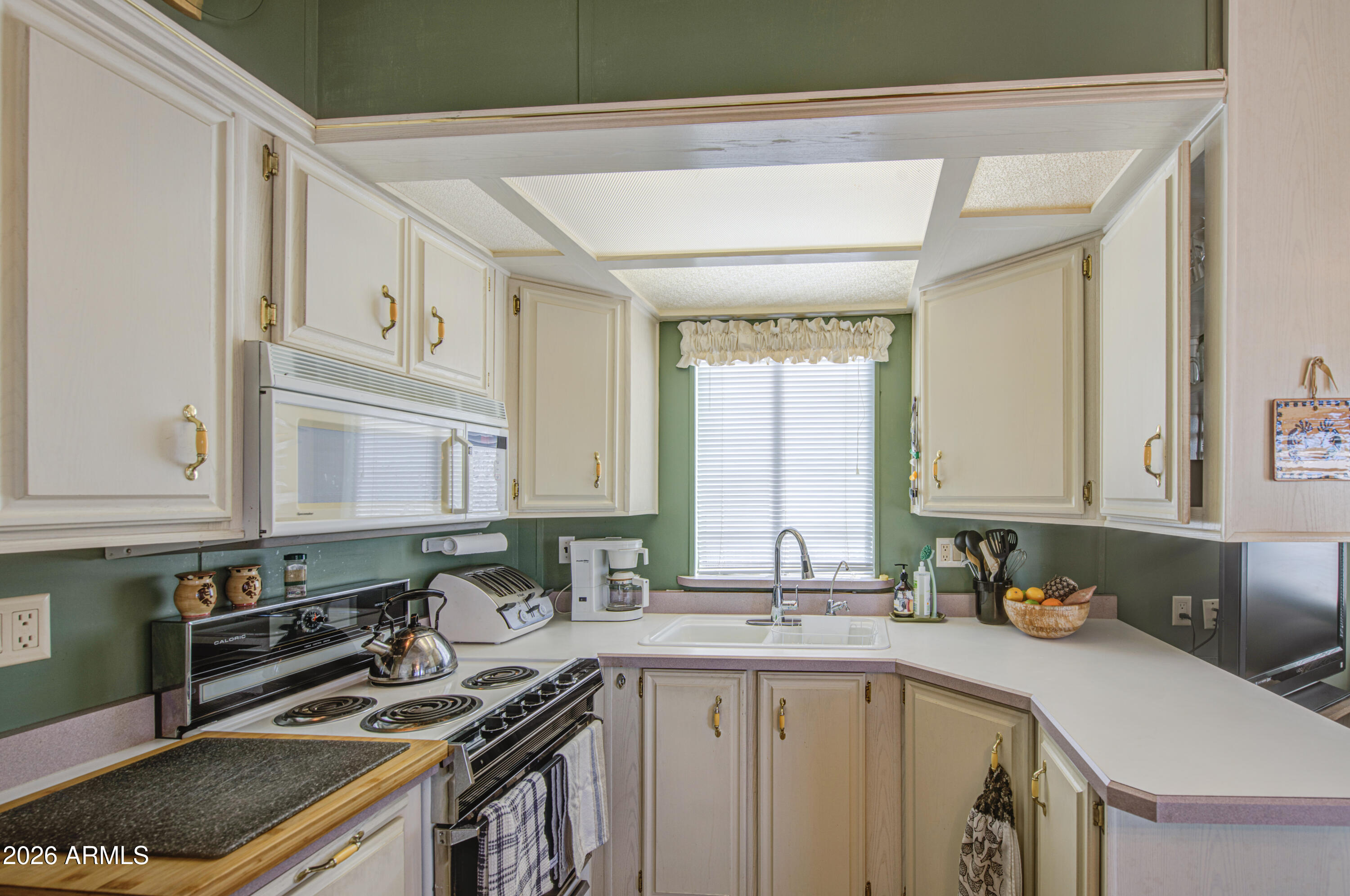 111 South Greenfield Road, Unit 408 Mesa, AZ 85206 - Photo 10 of 22 a kitchen with a sink stove and cabinets