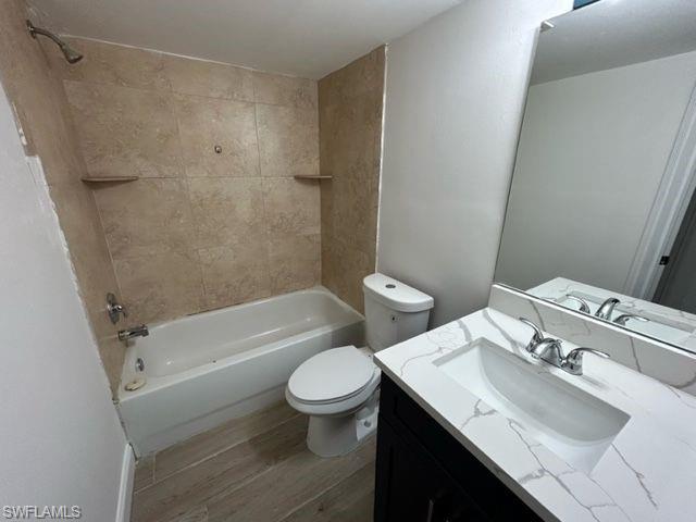 1555 Blue Point Avenue, Unit 3 Naples, FL 34102 - Photo 4 of 9 Full bathroom featuring vanity, hardwood / wood-style floors, tiled shower / bath combo, and toilet