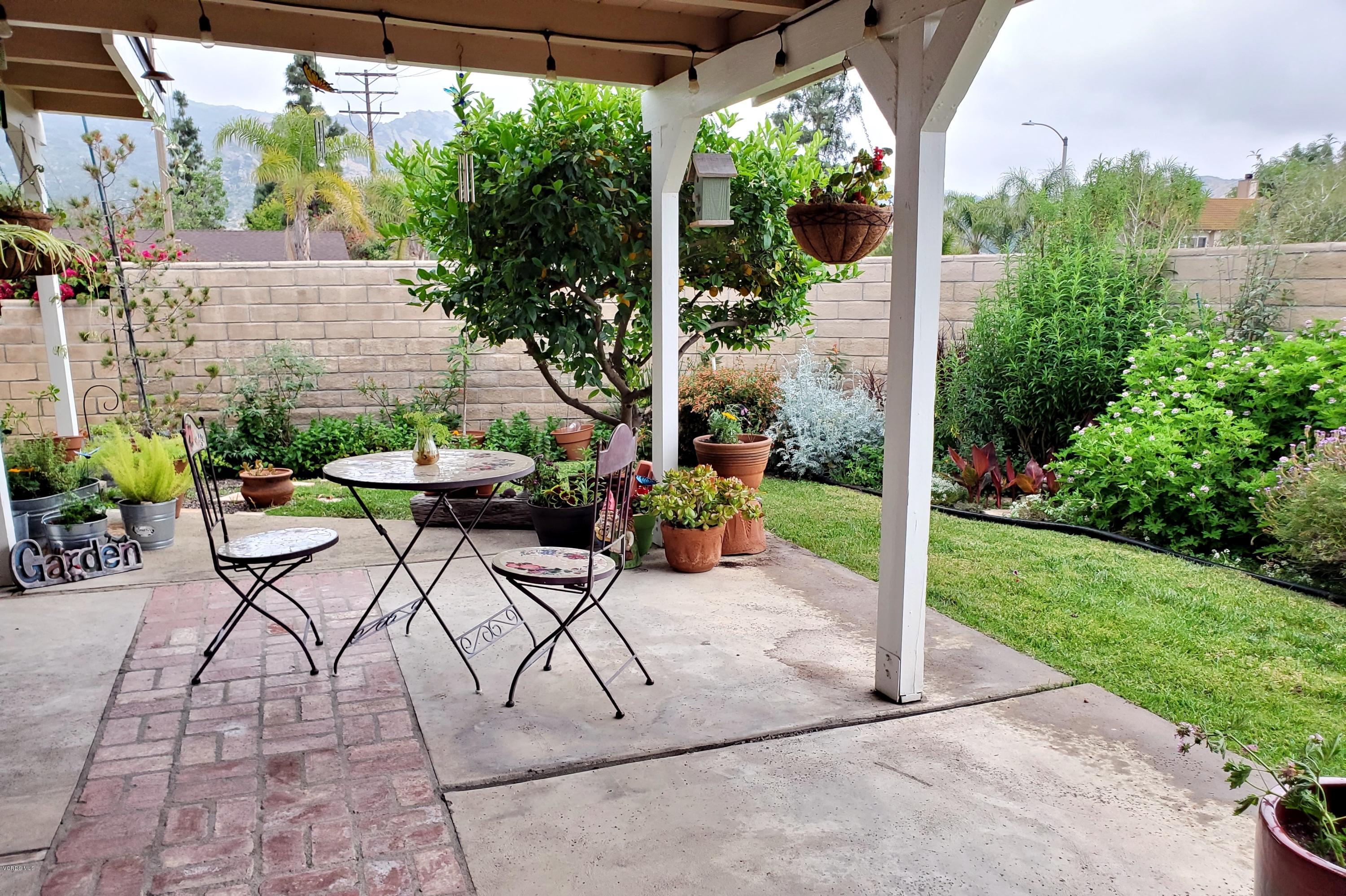 1817 Belhaven Avenue Simi Valley, CA 93063 - Photo 35 of 39 a view of a patio with table and chairs potted plants and palm trees