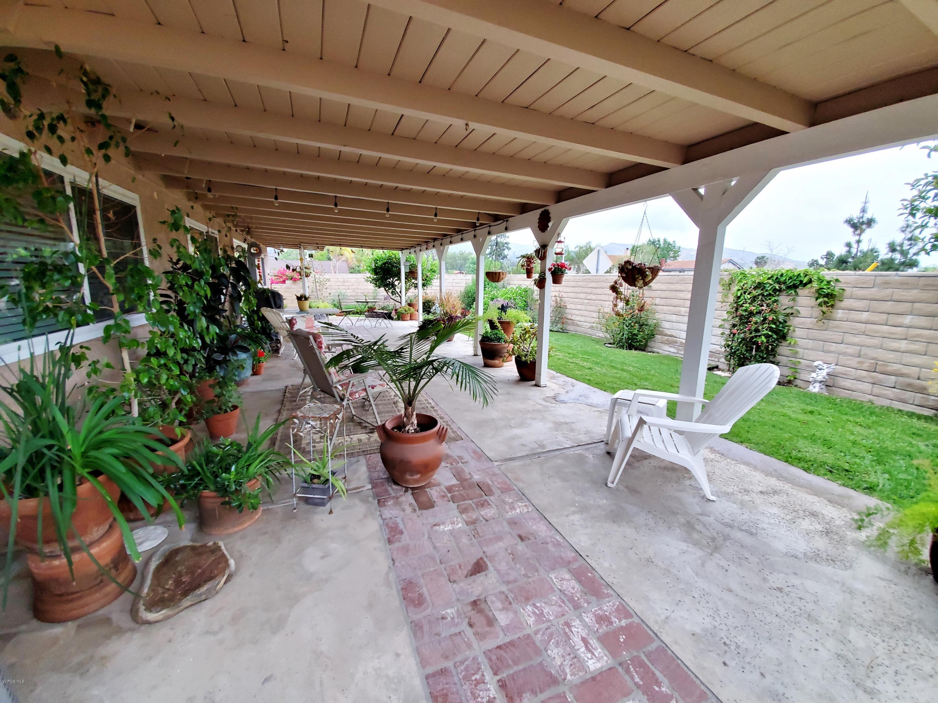 1817 Belhaven Avenue Simi Valley, CA 93063 - Photo 37 of 39 a view of a patio with table and chairs potted plants with wooden fence