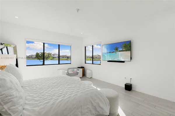 a bedroom with a large bed and a flat tv screen on the dresser
