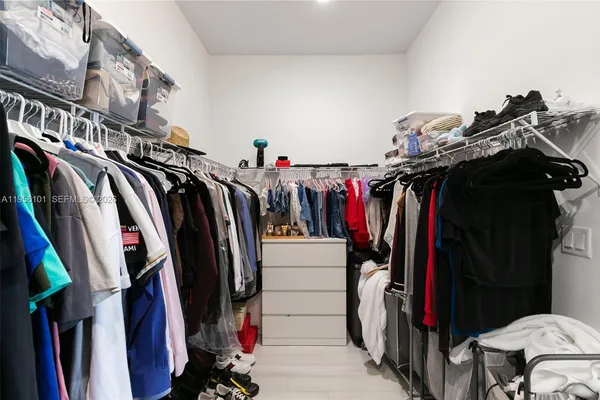 a view of walk in closet with clothes
