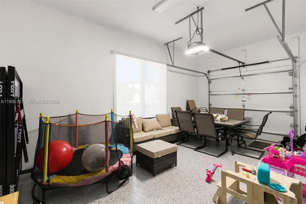 a living room with furniture a air conditioner and a flat screen tv