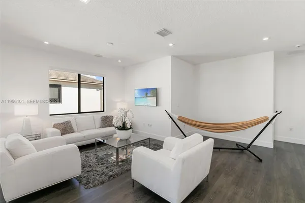 a living room with furniture and a wooden floor