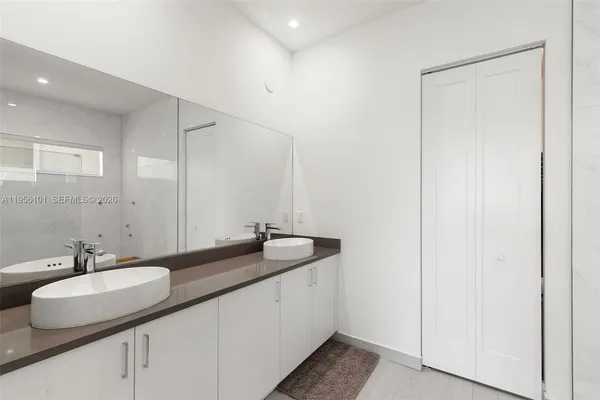 a bathroom with a granite countertop sink and a mirror