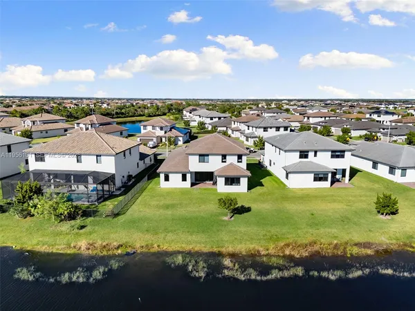 an aerial view of residential houses with outdoor space and trees